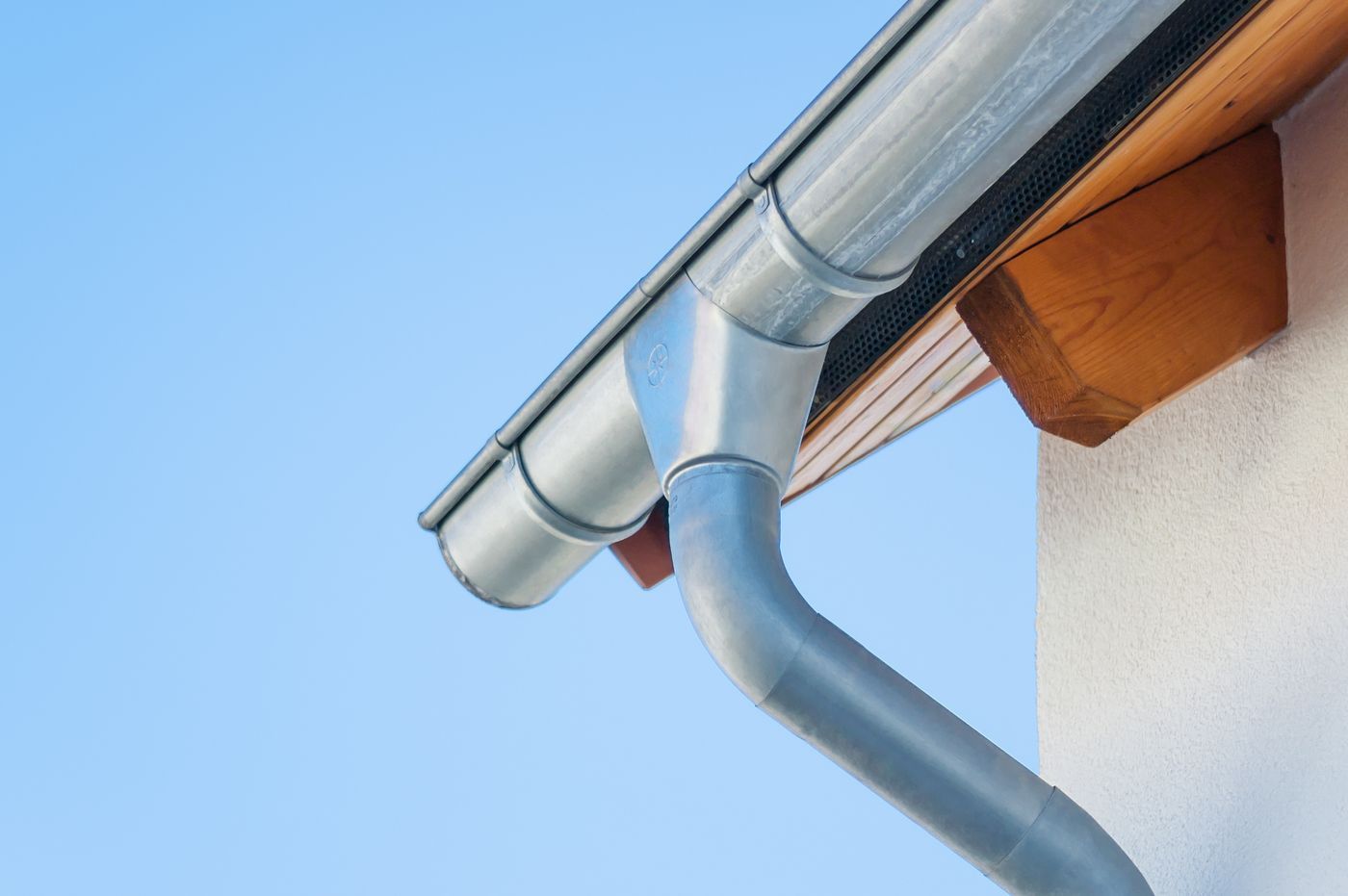 Neue Dachrinne mit Fallrohr an einem Wohnhaus