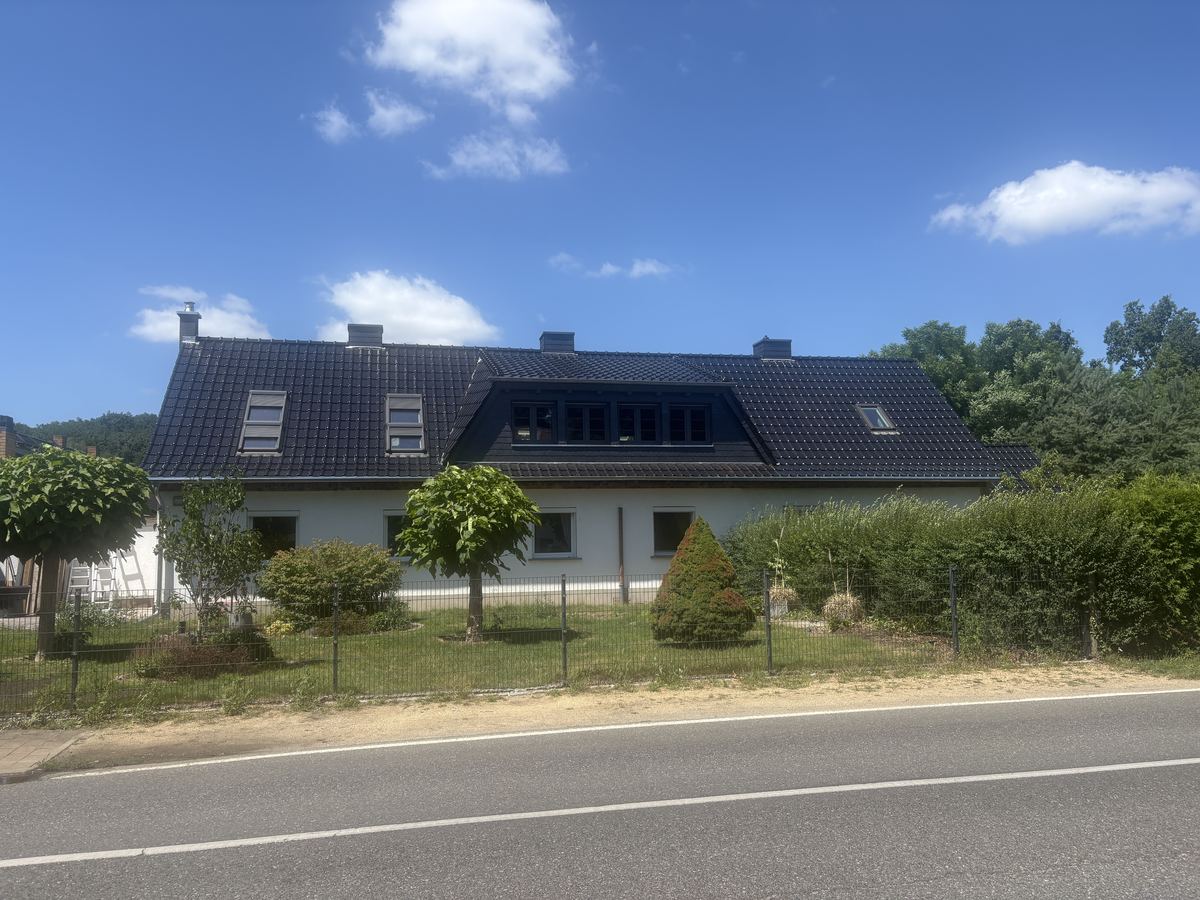 Dasselbe Haus mit neuer dunkler Eindeckung und Gaube